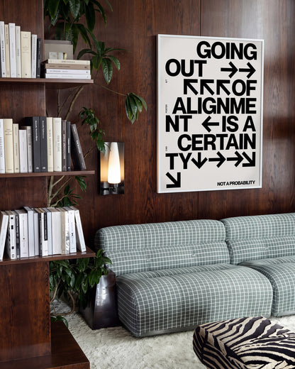 Out of Alignment typography quote print in a white frame on a wall
