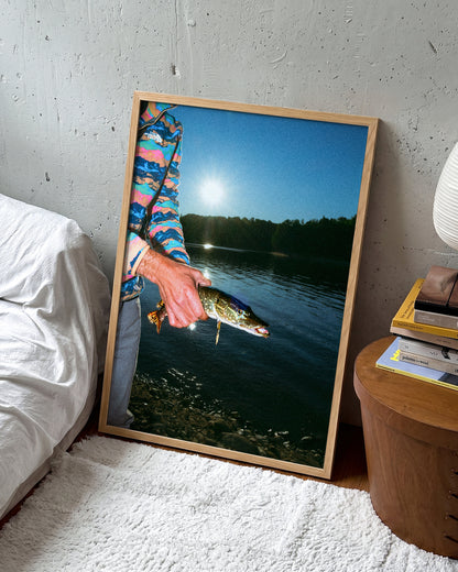 First Catch fishing photography print in an oak frame on a wall