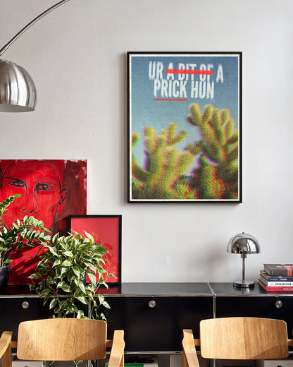 Bit of a Prick funny cactus quote poster in a black frame on a wall