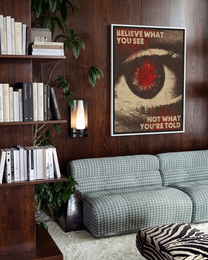 Believe What You See retro quote poster in a white frame on a wall